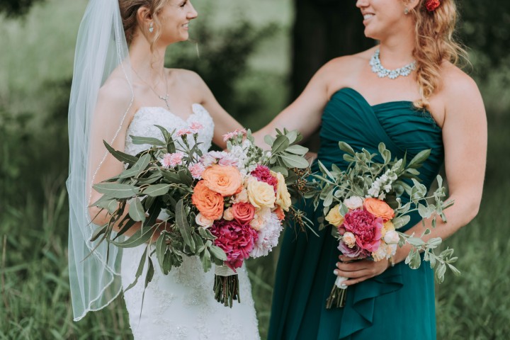 Bride and maid of honour holding floral bouquet
